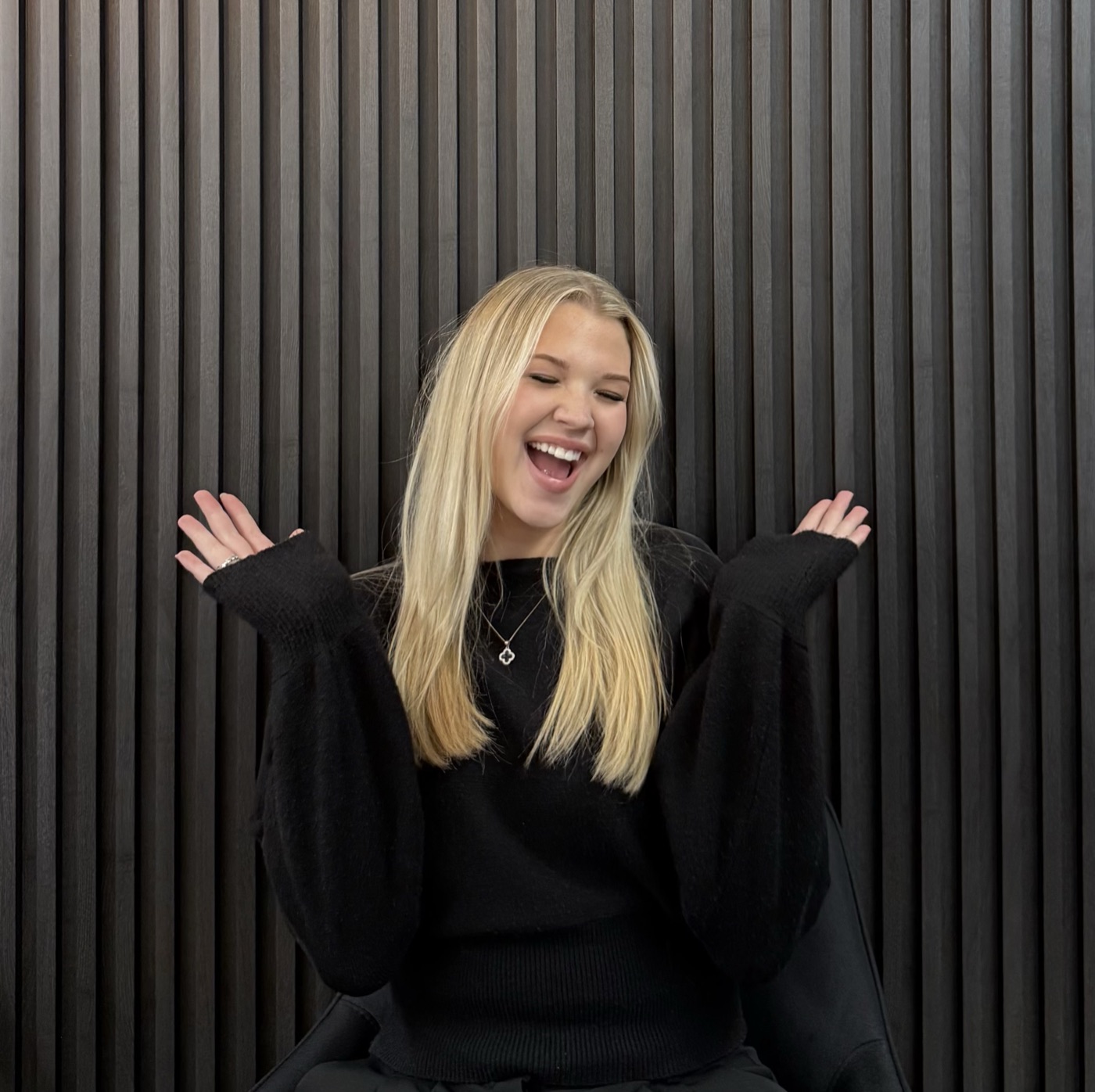 Abby laughing in front of the slat wall at The House of Cadence