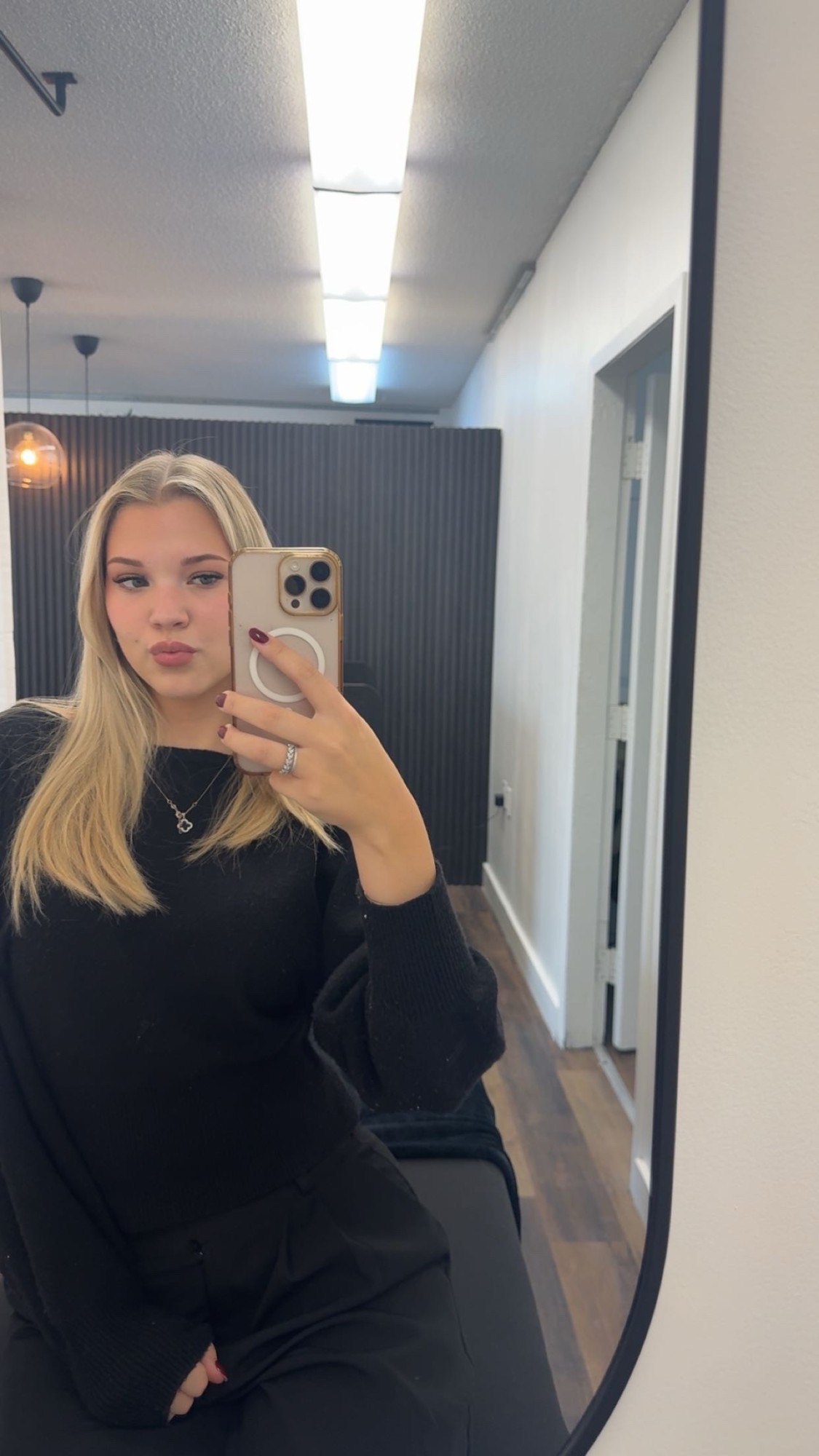 Abby taking a mirror selfie in her salon